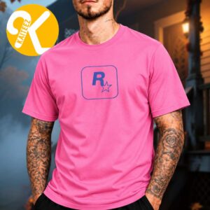 Male model wearing a bright pink T-shirt with a blue Rockstar R-star logo centered on the chest inside a rounded-square outline.